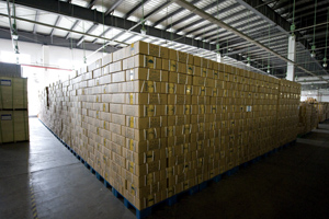 Stacks of Bibles await distribution in the Amity Printing Company warehouse in Nanjing, China. The woman at right anticipates receiving her own Bible in the Henan Province. <br/>Americanbible.org