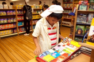 A Malaysian child on board of Logos Hope reading a picture book. <br/>gbaships.org