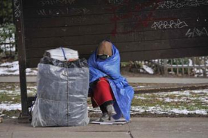 A homeless woman huddles from the cold while sitting on a bench at Gore Street and Georgia Street in Vancouver;BC Tuesday;January 17;2012. <br/>Jason Payne , PNG