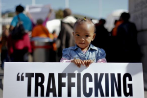A South African girl holds a poster during an anti-human trafficking protest outside of Parliament of Cape Town, South Africa 21 Sept. 2011. <br/>EPA/NIC BOTHMA