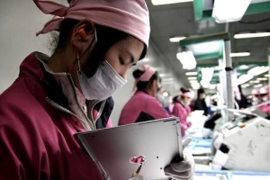 A Foxconn workers files down the iconic Apple logo a the company's iPad production plant in Chengdu, China. Workers say they can each process up to 6,000 units per day. <br/>(Almin Karamehmedovic/ABC News)