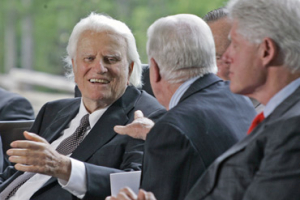 Billy Graham, left, reaches out to former President Jimmy Carter as Bill Clinton, far right looks on during the dedication for the Billy Graham Library in Charlotte, N.C., Thursday, May 31, 2007. <br/>(Photo: AP Images / Chuck Burton, File)