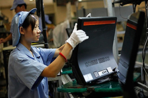 A Chinese worker works on a Lenovo production line in Shanghai. <br/>Eugene Hoshiko/AP