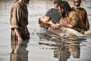 This publicity image released by History shows Diogo Morcaldo as Jesus, center, being baptized by Daniel Percival, as John, in a scene from ''The Bible,'' which premiered March 3 on History. <br/>