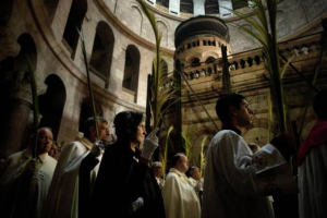 Palm greeters: Catholic priests carry palm fronds at the Church of the Holy Sepulcher, traditionally believed by many to be the site of the crucifixion and burial of Jesus Christ, in Jerusalem's Old City on Sunday. <br/>AP