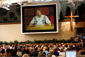 The Rev. Rick Warren, on a jumbo television screen, preaching at the Saddleback Church in Lake Forest, Calif. in October 2006. <br/>Monica Almeida/The New York Times