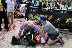 A woman was tended to at the scene of the first explosion. <br/> John Tlumacki/The Boston Globe