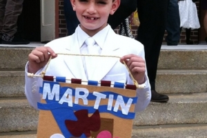 This undated photo provided by Bill Richard, shows his son, Martin Richard, holding a communion banner. On it, the dove symbolizes Holy Spirit. <br/>Bill Richard via AP