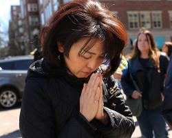 A woman prays at a security gate near the scene of yesterday’s bombing attack at the Boston Marathon on April 16, 2013 in Boston, Massachusetts. The twin bombings, which occurred near the marathon finish line, resulted in the deaths of three people. <br/>Photo by Spencer Platt/Getty Images