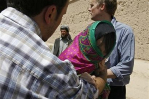 One of the three South Korean hostages is escorted after being released in the city of Ghazni August 29, 2007. Taliban insurgents freed three South Korean women hostages on Wednesday, the first of 19 Christian volunteers the Taliban agreed to release after South Korea said it would pull its troops out of Afghanistan. <br/>(Mohammad Ishaq/Reuters) 