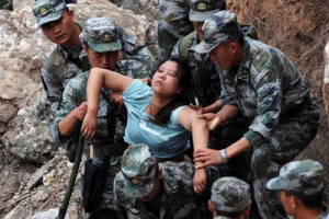 Rescuers save an injured woman after a 6.6 earthquake hit Baosheng Township in Lushan County, Ya'an City, in China's Sichuan Province on Saturday, April 20, 2013. The powerful earthquake struck the steep hills of Sichuan province Saturday, nearly five years after a devastating quake wreaked widespread damage across the region. <br/> Jiang Hongjing, AP