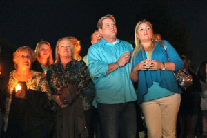 Audrie Pott's family, including her mother, Sheila Pott, second left, father Larry Pott, and stepmother, Lisa Pott, listen to speakers during a candlelight vigil for Audrie Pott at Saratoga High School in Saratoga, Calif. on Friday, April 19, 2013. <br/> (Jim Gensheimer/Bay Area News Group)