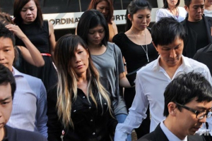 Kong Hee (R in white) with his wife Sun Ho as they leave the subordinate courts in Singapore. <br/> (AFP Photo/Roslan Rahman)