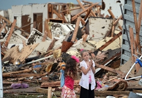 Two girls stand in the rubble after a massive tornado struck Moore, Okla. on May 20, 2013. <br/>