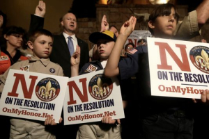 Boy Scouts from right, Joey Kalich, 10, Steven Grime, 7, and Jonathan Grime, 9, raise their hands at the close of a news conference held by peopel against change in the Boy Scouts of America gay policy Wednesday, May 22, 2013, in Grapevine, Texas. <br/>L.M. Otero, AP