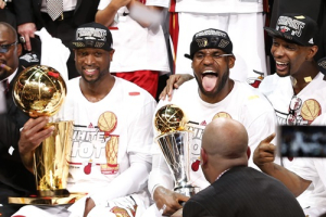 Miami Heat's LeBron James (C) holds the Bill Russell MVP Trophy as Dwyane Wade (L) holds the Larry O'Brien Trophy while Chris Bosh celebrates after their team defeated the San Antonio Spurs in Game 7 to win their NBA Finals basketball playoff in Miami, Florida June 20, 2013. <br/>REUTERS/Mike Segar
