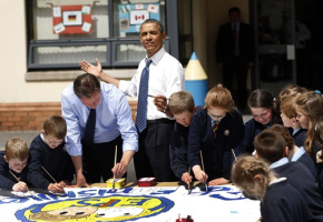 U.S. President Barack Obama reacts as the sun comes out as he works alongside Britain's Prime Minister David Cameron and students on a school project about the G8 summit during a visit to the Enniskillen Integrated Primary School in Enniskillen, Northern Ireland, Monday, June 17, 2013. <br/>REUTERS/Matt Dunham/POOL