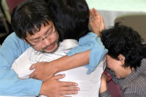 Che Chang-hee, left, one of the 19 released South Korean hostages, reunites his family members on his arrival at a hospital in Anyang, west of Seoul, South Korea, Sunday, Sept. 2, 2007. Nineteen South Koreans freed last week from a six-week captivity by Taliban insurgents arrived home Sunday, expressing sorrow for two in their group who were killed in Afghanistan and apologizing to the nation. <br/>(Photo: Yonhap / Shin Young-keun)