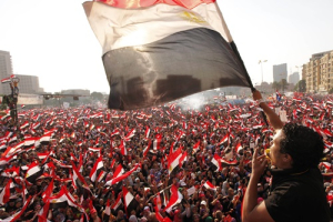 Protesters against Egyptian President Mohamed Mursi wave national flags in Tahrir Square in Cairo July 3, 2013. The Egyptian president's national security adviser said on Wednesday that a ''military coup'' was under way and army and police violence was expected to remove pro-Mursi demonstrators. <br/>REUTERS/Mohamed Abd El Ghany 
