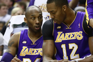 Los Angeles Lakers guard Kobe Bryant (L) talks to Lakers center Dwight Howard while drawing on a board during the first half of an NBA basketball game against Indiana Pacers in Indianapolis, Indiana March 15, 2013. <br/>REUTERS/Brent Smith 