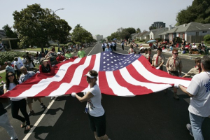 Parade participants carry a large U.S. flag during the Los Angeles neighborhood of Westchester's 14th annual Fourth of July Parade in Los Angeles, California, July 4, 2013. <br/>REUTERS/Jonathan Alcorn 