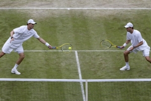 Bob Bryan of the U.S. (LEFT), with his partner Mike Bryan of the U.S., hits a return to Rohan Bopanna of India and Edouard Roger-Vasselin of France in their men's doubles semi-final tennis match at the Wimbledon Tennis Championships, in London July 4, 2013. <br/>