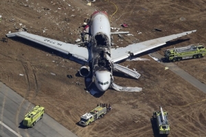 Firefighters surround an Asiana Airlines Boeing 777 plane after it crashed while landing at San Francisco International Airport in California on July 6, 2013. Two people were killed and 130 were hospitalized after the plane crash-landed at San Francisco International Airport on Saturday morning, San Francisco Fire Department Chief Joanna Hayes-White said. The figures cited by Hayes-White leave 69 people still unaccounted for in the accident. The Boeing 777, which had flown from Seoul, South Korea, was carrying 307 people. <br/>REUTERS/Jed Jacobsohn 