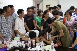 Parents of Wang Linjia, center, are comforted by other parents Sunday at Jiangshan Middle School in Jiangshan city, in eastern China's Zhejiang province. <br/>AP