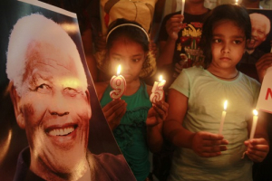 Students hold candles and a portrait of Nelson Mandela during the celebrations to mark Mandela's 95th birthday in Agartala, capital of India's northeastern state of Tripura July 18, 2013. REUTERS/Jayanta Dey <br/>