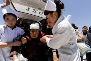 Nurses support an injured woman who is taken to a hospital in Minxian county, Dingxi, Gansu province, July 22, 2013. <br/>Reuters