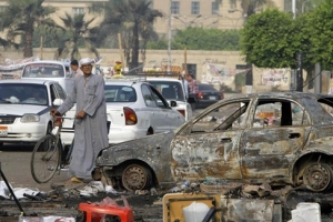 An Egyptian walked in front of a burned-out car and leftover debris from a protest camp in Cairo on Thursday. <br/>Amr Nabil/Associated Press