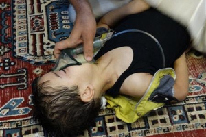 A boy, affected by what activists say is nerve gas, breathes through an oxygen mask in the Damascus suburb of Saqba, August 21, 2013 in this handout provided by Shaam News Network. <br/>Reuters/Maher al-Zaybaq/Shaam News Network