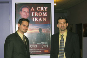 (l-r) Andre and Joseph Hovsepian, the son of martyred Bishop Haik Hovsepian, in front of a poster for their documentary A Cry From Iran about the death of their father. <br/>(Photo: Hovsepian Ministries)
