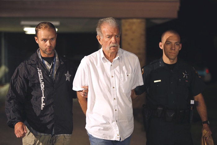 Pastor Terry Jones is escorted by Polk County Sheriff's Deputies to a waiting patrol car at their PCSO Southwest District substation in Lakeland, Florida September 11, 2013. Jones was arrested for the unlawful open carry of a firearm and the unlawful conveyance of fuel. REUTERS/Pierre DuCharme