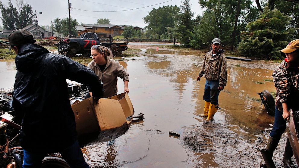Local residents, left to right, Levi Wolfe, Miranda Woodard, Tyler Sadar, and Genevieve Marquez help salvage and clean property in an area inundated after days of flooding, in Hygeine, Colo., Sept. 16, 2013. Brennan Linsley/AP Photo