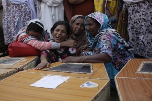 Christian women mourn next to the coffins of their relatives, who were killed in a suicide attack on a church, in Peshawar September 22, 2013. A pair of suicide bombers blew themselves up outside the 130-year-old church in Pakistan after Sunday Mass, killing at least 56 people in the deadliest attack on Christians in the predominantly Muslim South Asian country. <br/>REUTERS/Fayaz Aziz 