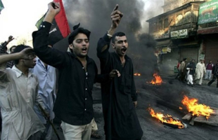 Angry supporters of slain opposition leader Benazir Bhutto chant slogans after burning tires during a protest rally, Friday, Dec. 28, 2007, in Rawalpindi, Pakistan. Bhutto's supporters rampaged through cities to protest her assassination less than two weeks before a crucial election, ransacking banks and setting train stations ablaze, officials said. <br/>(Photo: AP Images / Anjum Naveed)