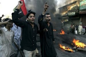 Angry supporters of slain opposition leader Benazir Bhutto chant slogans after burning tires during a protest rally, Friday, Dec. 28, 2007, in Rawalpindi, Pakistan. Bhutto's supporters rampaged through cities to protest her assassination less than two weeks before a crucial election, ransacking banks and setting train stations ablaze, officials said. <br/>(Photo: AP Images / Anjum Naveed)