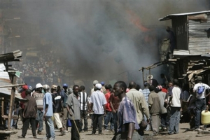 Protesters stand in front of burning buildings, Wednesday, Jan. 2, 2008 during riots in the Mathare slum in Nairobi, Kenya. The head of the African Union was traveling to Kenya Wednesday for crisis talks to end an explosion of postelection violence that has killed more than 275 people, including dozens burned alive as they sought refuge in a church. <br/>(Photo: AP Images / Karel Prinsloo)