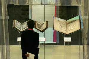 A visitor looks at a volume of The Hebrew Bible from Lisbon, Portugal dated 1482, left, The New Testament from Constantinople from the mid 10th century, centre, and a 1310 Royal Quran from Mosul, Iraq, in the 'Sacred : Discover what we share' exhibition at the British Library in London, Wednesday, April 25, 2007. The exhibition brought together important religious texts from the Jewish, Christian and Muslim faiths. <br/>(Photo: AP Images / Sang Tan)