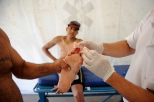 A man is treated after he was bit by a palometa, a type of piranha, while wading in the Parana River in Rosario, Argentina, Wednesday, Dec. 25, 2013. Lifeguards director Federico Cornier said Thursday that thousands of bathers were cooling off from 100 degree temperatures in the Parana River on Wednesday when bathers suddenly came to them complaining of bite marks on their hands and feet. Photo By Silvina Salinas <br/>