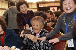 North Korean Jeong Sook-Yong (C) and her South Korean relatives laugh as they look at an instant photo during inter-Korean temporary family reunions at Mount Kumgang resort October 31, 2010. REUTERS/Kim Ho-Young/Korea Pool <br/>