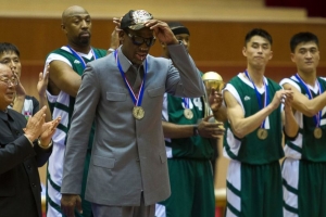 Dennis Rodman tips his hat as U.S. and North Korean basketball players applaud at the end of an exhibition basketball game at an indoor stadium in Pyongyang, North Korea on Jan. 8, 2014. AP Photo <br/>