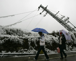 Residents walk past a damaged electrical pole in a village about 200 miles north of China's southern city of Guangzhou. Emergency crews struggled to restore power to parts of southern China blacked out for more than 10 days by heavy snow as forecasters warned of no quick end to the worst winter weather in 50 years. <br/>REUTERS/Bobby Yip (CHINA) 