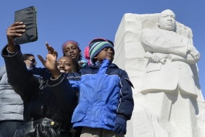 A family takes a self portrait of themselves at the Martin Luther King Memorial, in Washington, January 19, 2014. The nation honors the legacy of the slain civil rights leader and Nobel Peace Prize laureate with a national holiday January 20. REUTERS/Mike Theiler <br/>