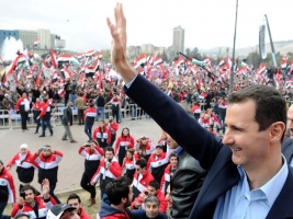 Syrian President Bashar al-Assad waves at supporters during a rare public appearance in Damascus Wednesday in which he vowed to defeat a 