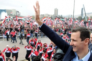 Syrian President Bashar al-Assad waves at supporters during a rare public appearance in Damascus Wednesday in which he vowed to defeat a 