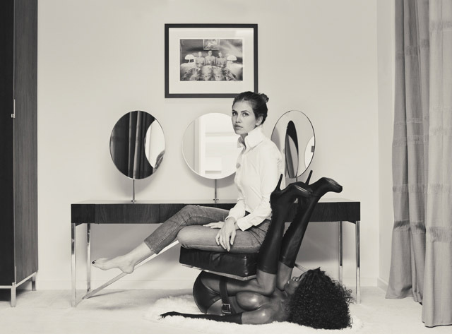 Controversial picture of woman sitting on a black woman as a chair