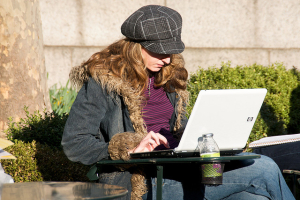 A woman uses her laptop while at a park. (Ed Yourdon via Flickr cc) <br/>