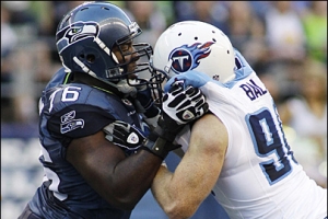 Russell Okung, left, tries to keep Tennessee Titans' David Ball, right, away from Seahawks quarterback Matt Hasselbeck in the first half of an NFL preseason football game, Saturday, Aug. 14, 2010, in Seattle. <br/>